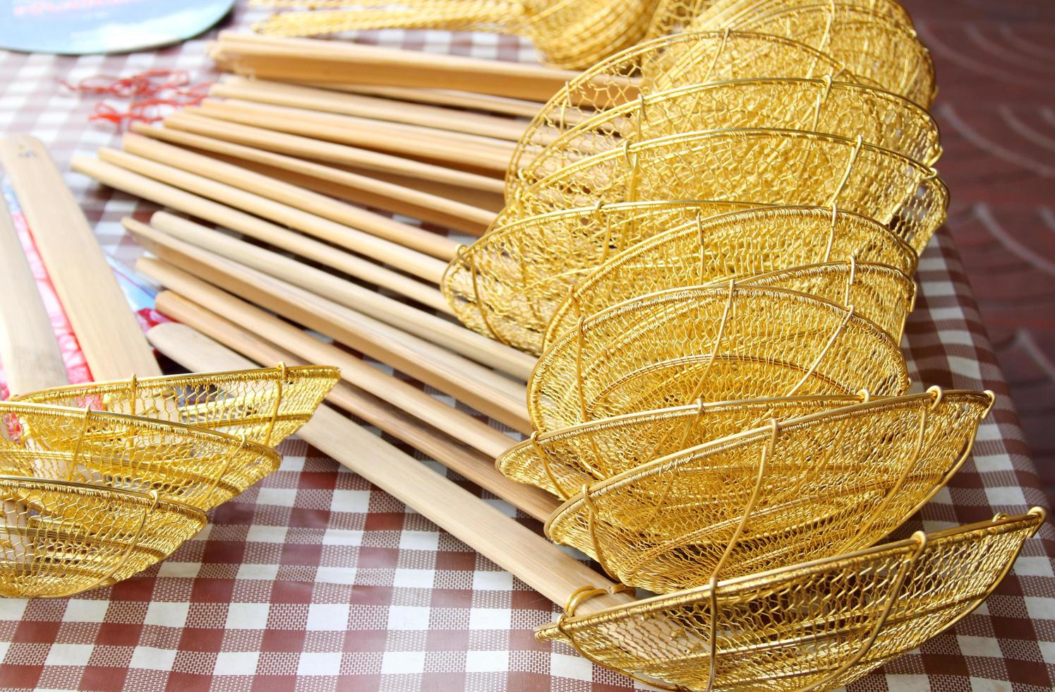 Strainer to boil noodles traditional style on table for sale, handle made from bamboo, Thailand. photo
