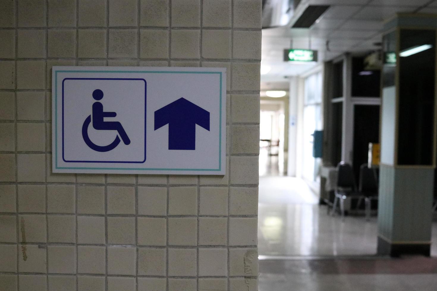 Sign wheelchair way is on light brown wall in building. photo