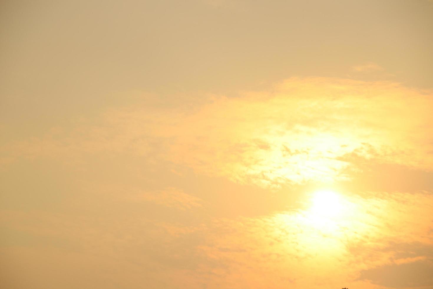 Orange sun light sky background from sun behind thin cloud. photo