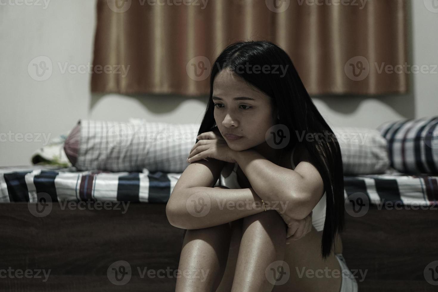 Asian woman sitting in the bedroom crying photo