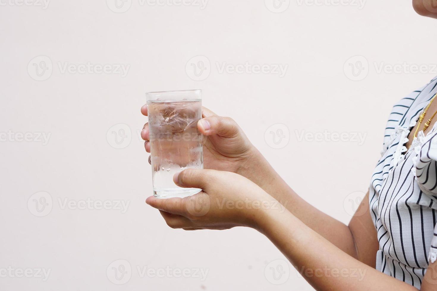 mujer asiática sosteniendo un vaso de agua fría para beber foto