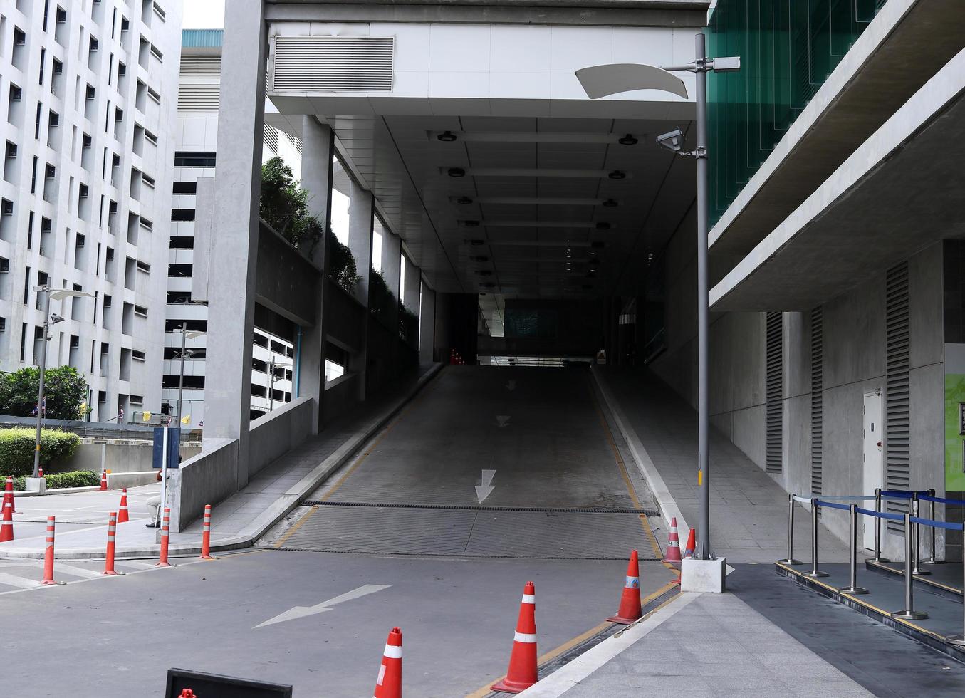 el camino hacia abajo del edificio en bangkok, tailandia. un coche pasa por aquí después de aparcar en el segundo piso y lleva gente. foto