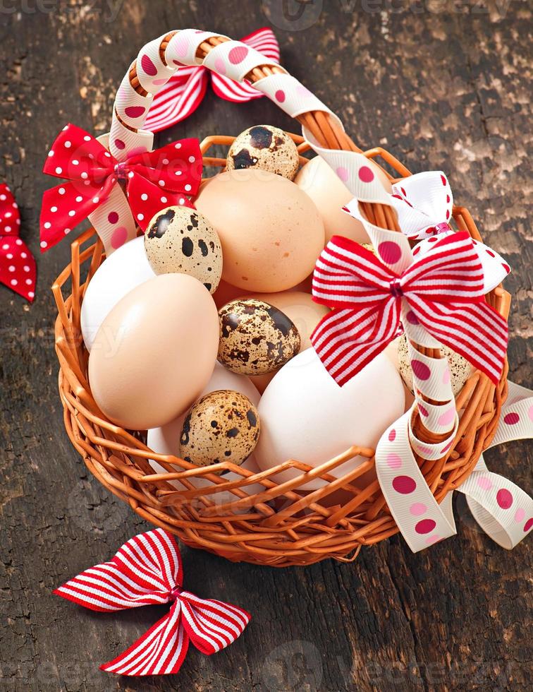 Easter eggs and basket on a wooden background photo