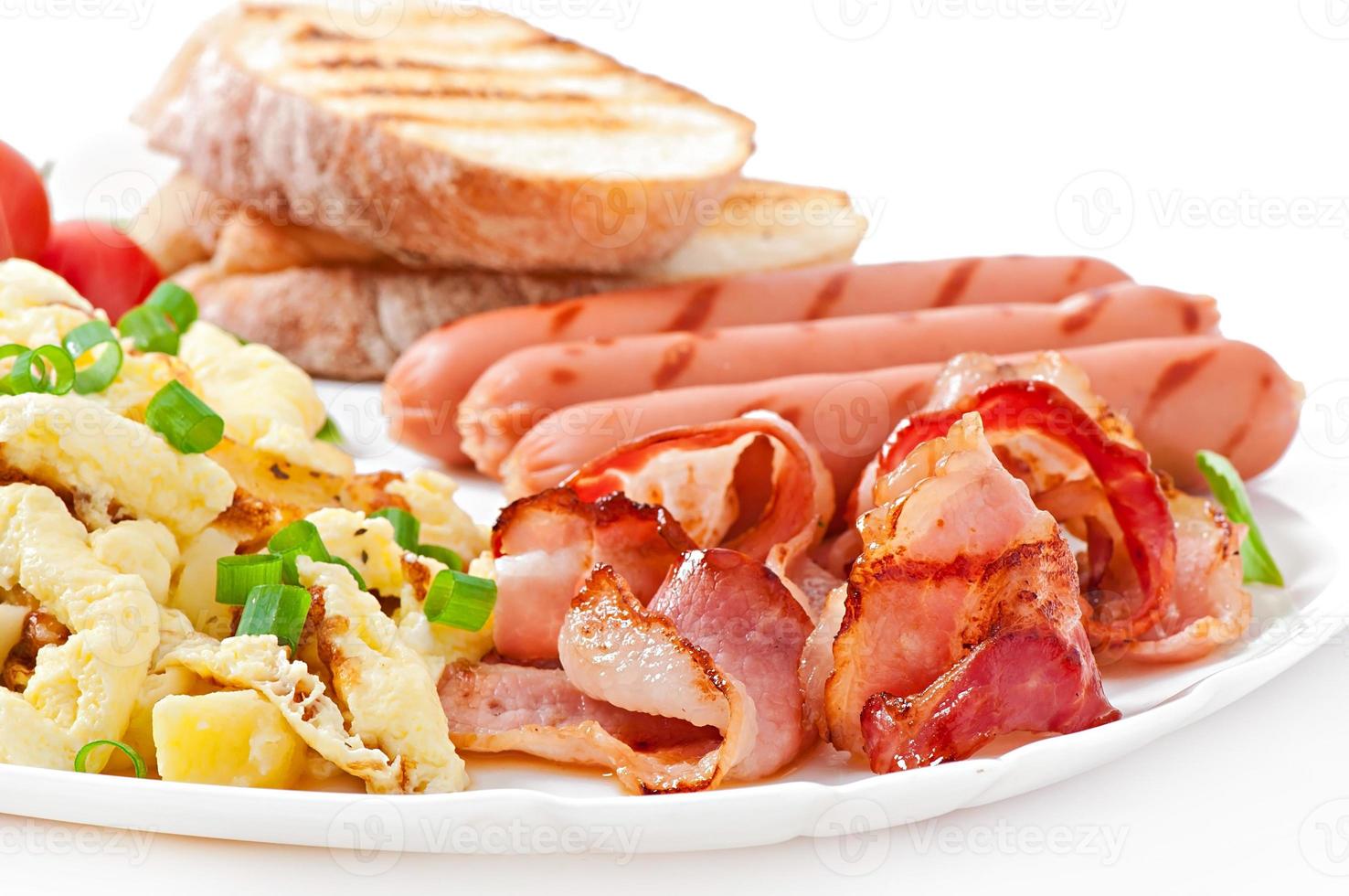 English breakfast - scrambled eggs, bacon, sausage and toast photo