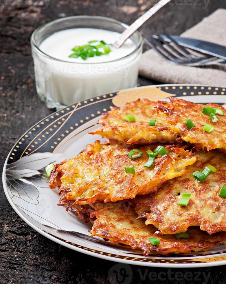 Fried potato pancakes on the old wooden background photo