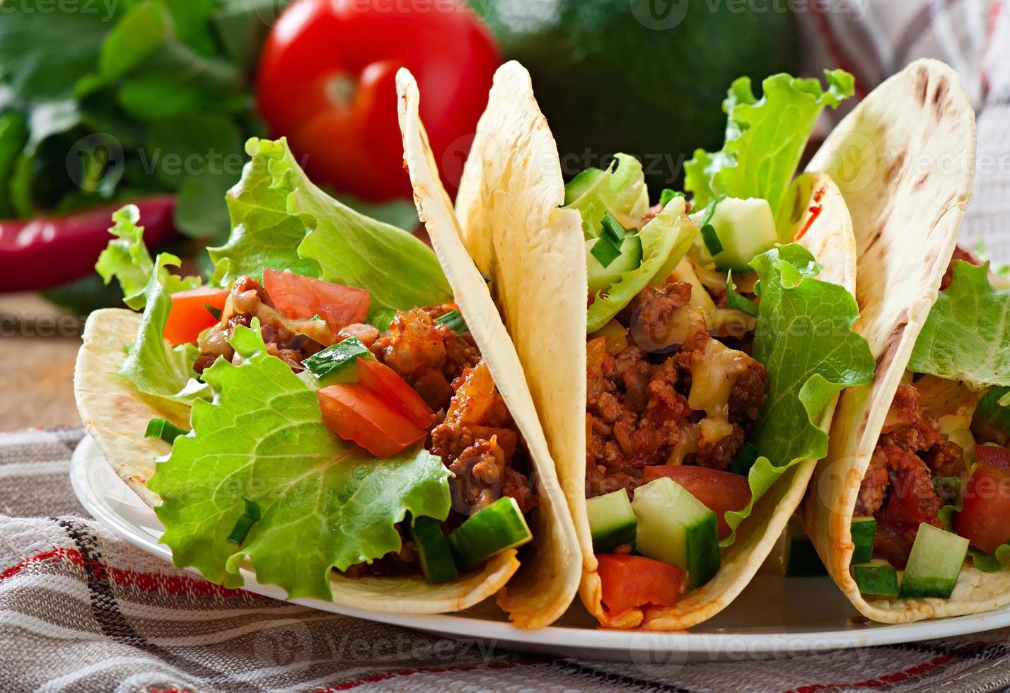 Mexican tacos with meat, vegetables and cheese photo