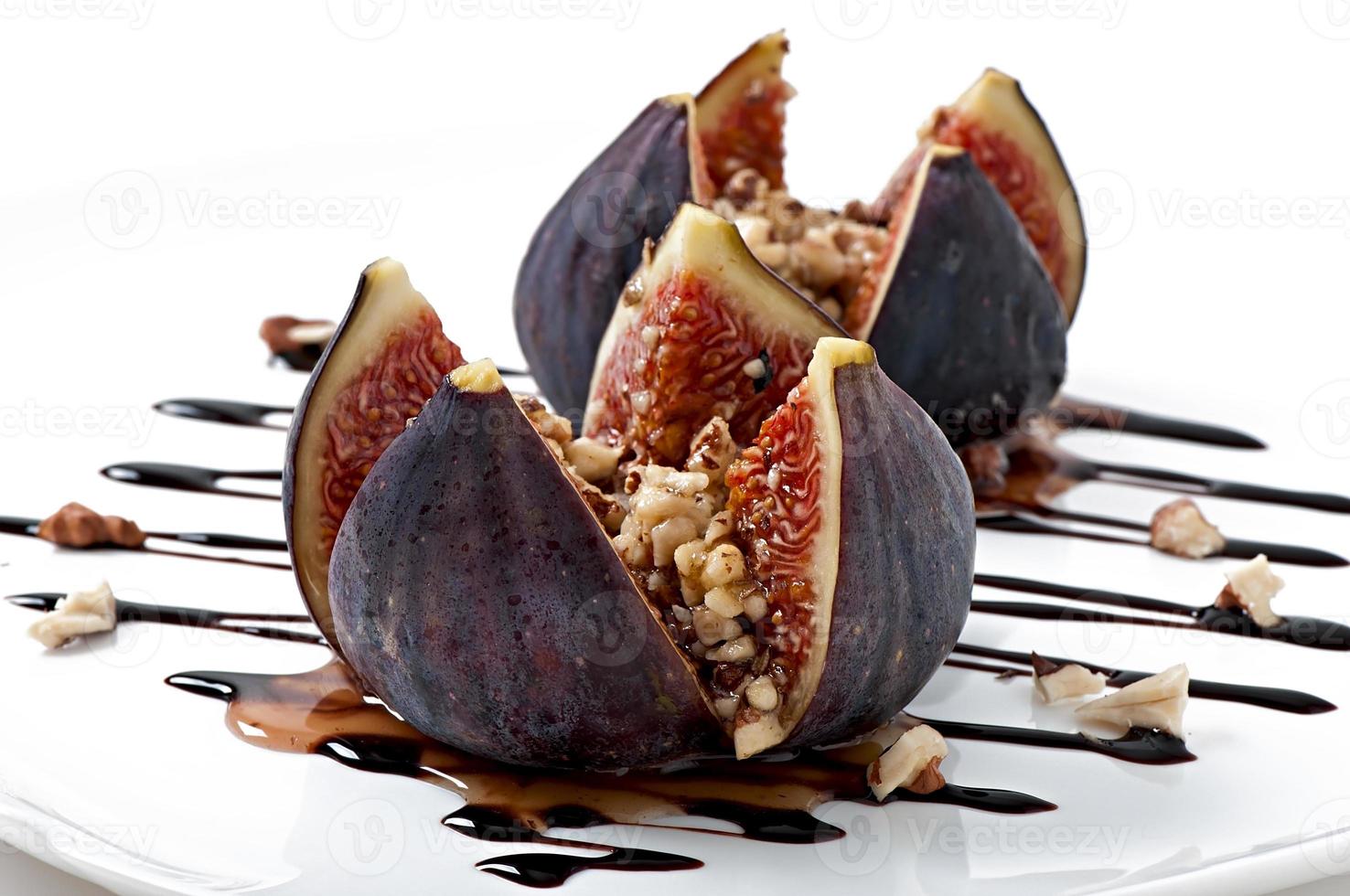 Ripe figs on a white plate cut into quarters photo