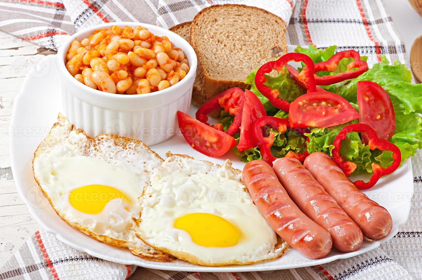 desayuno inglés - salchichas, huevos, frijoles y ensalada foto