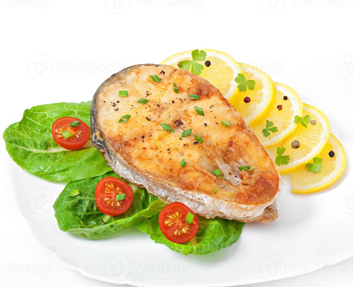 Fish dish - fried fish fillet with vegetables on white background photo