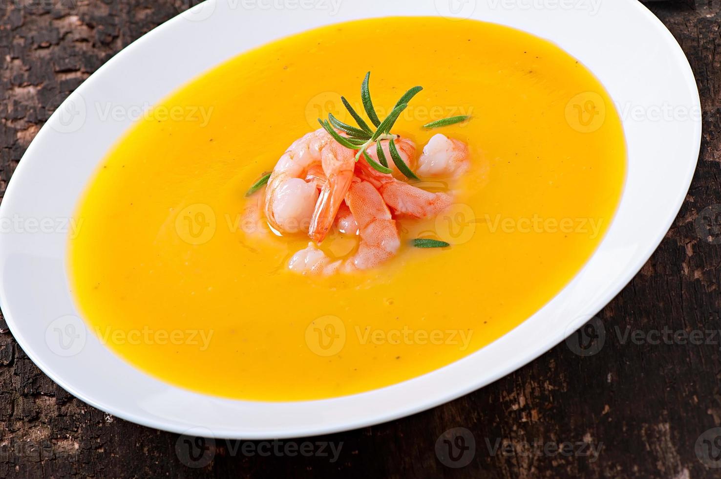 Pumpkin soup with shrimp and rosemary photo