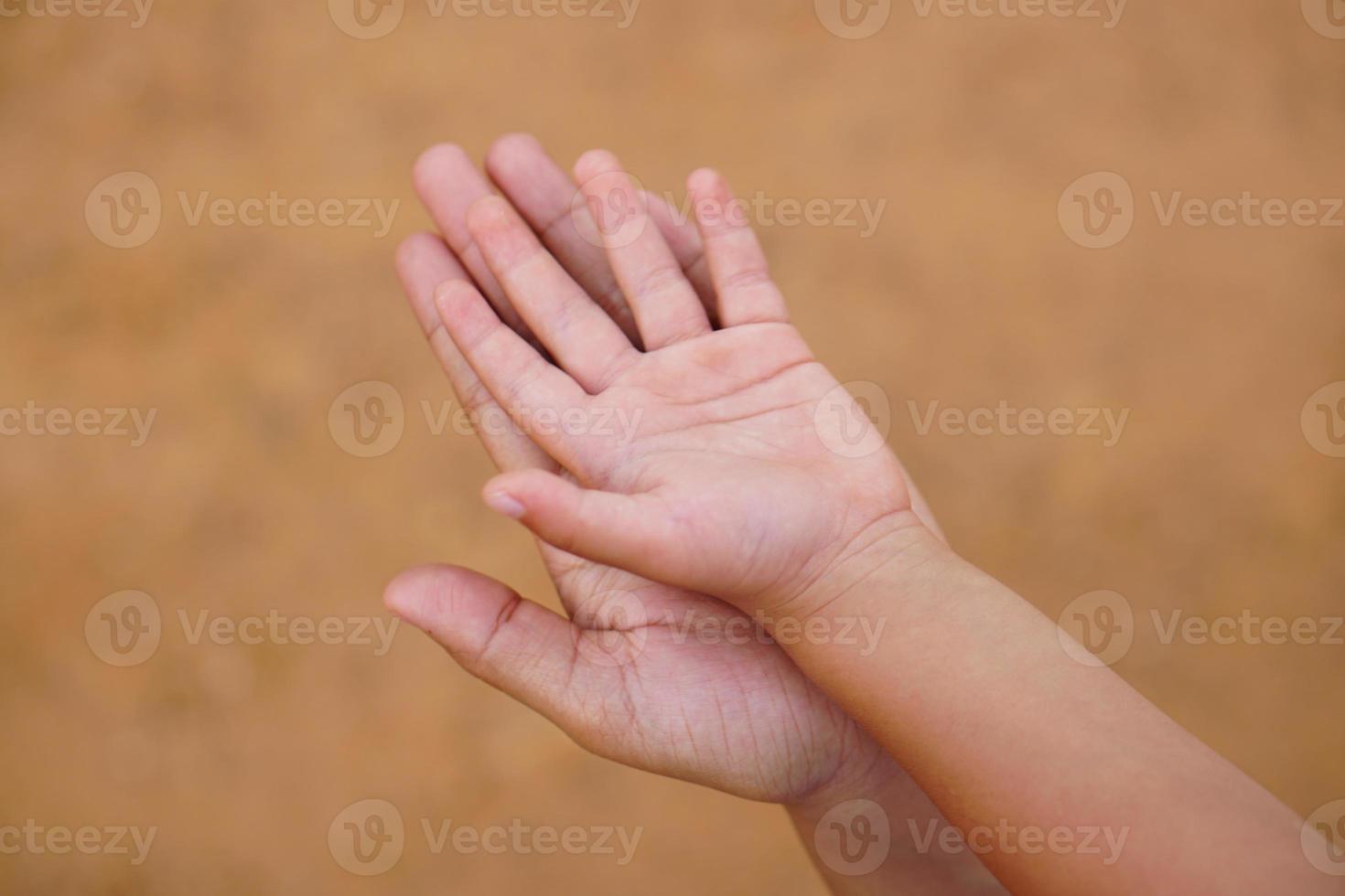 madre e hijo tomados de la mano para recibir algo foto