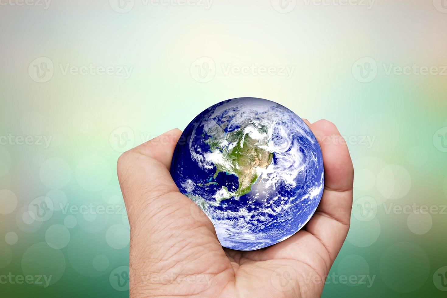 Earth conservation concept. The world of hearts floats above human hands. nature blur background photo