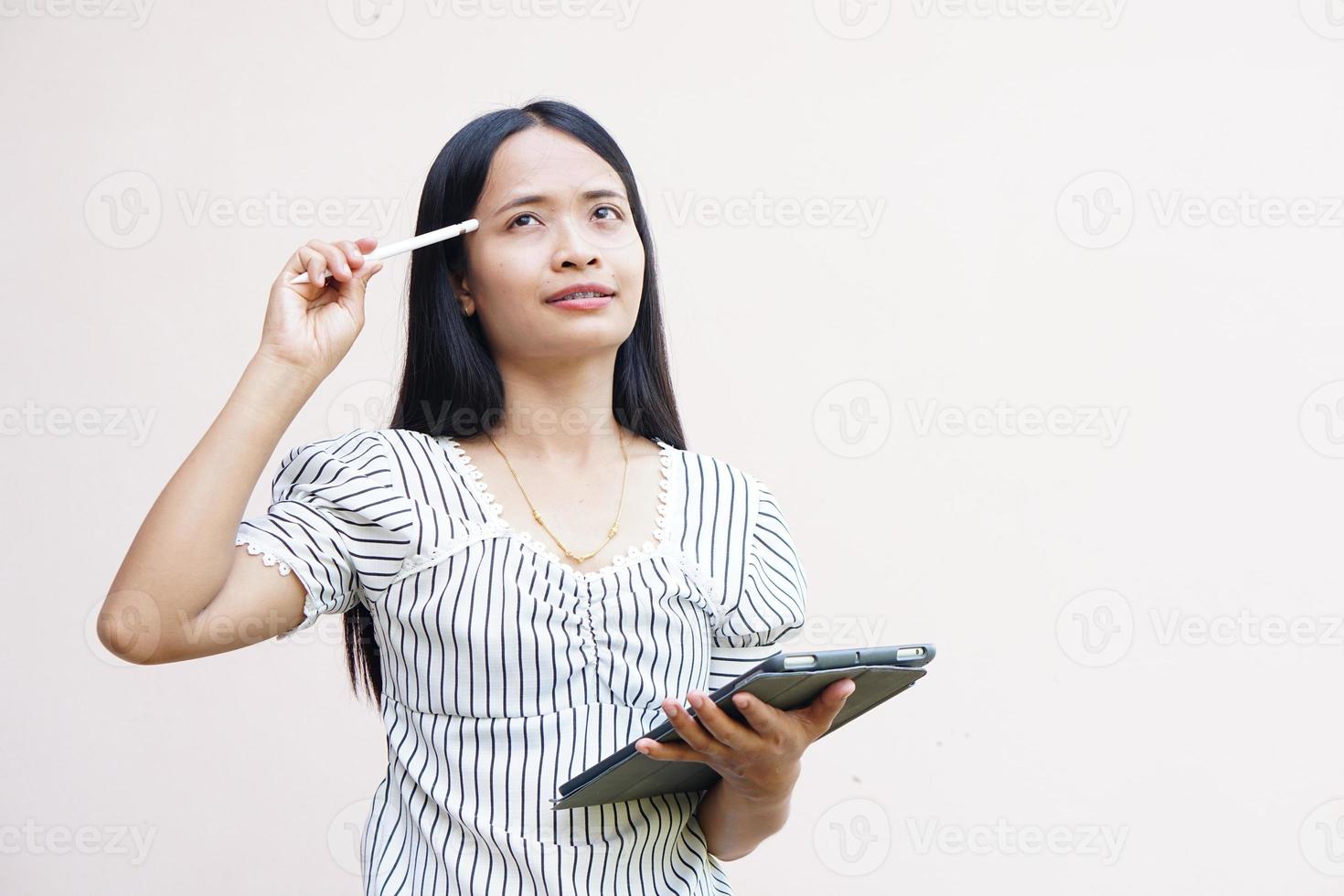 Asian woman looking at a portable computer monitor and devise a business plan photo