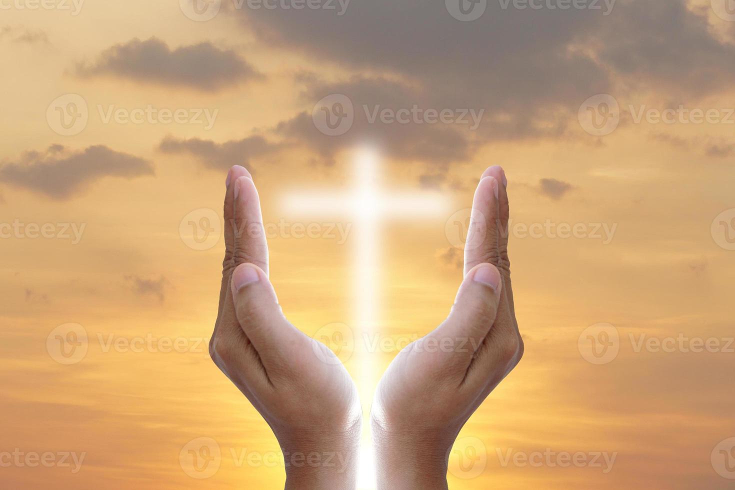 Hands bless the cross in the sky. photo