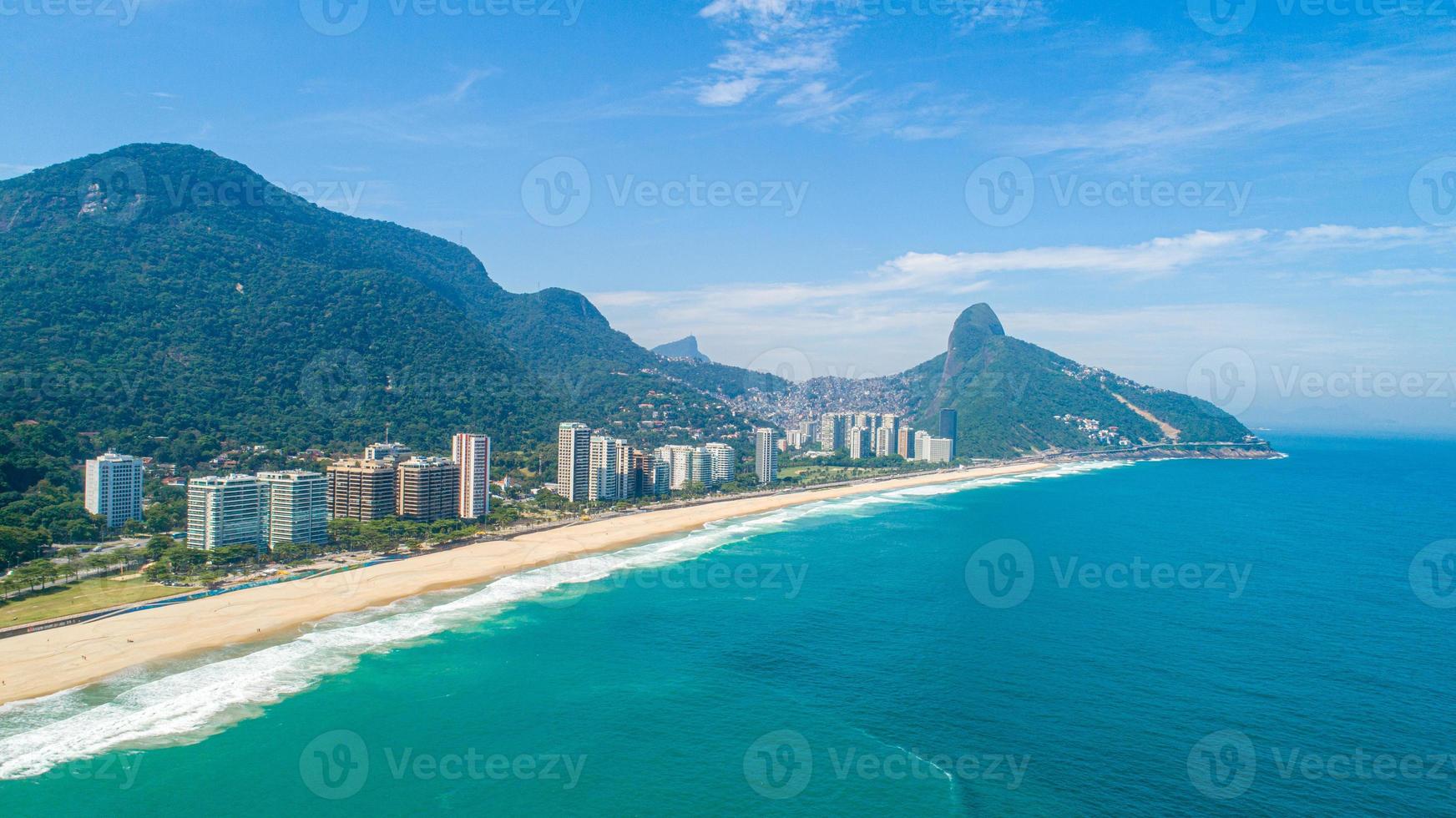 Aerial view of Favela da Rocinha, Biggest Slum in Brazil on the Mountain in Rio de Janeiro, and Skyline of the City behind photo