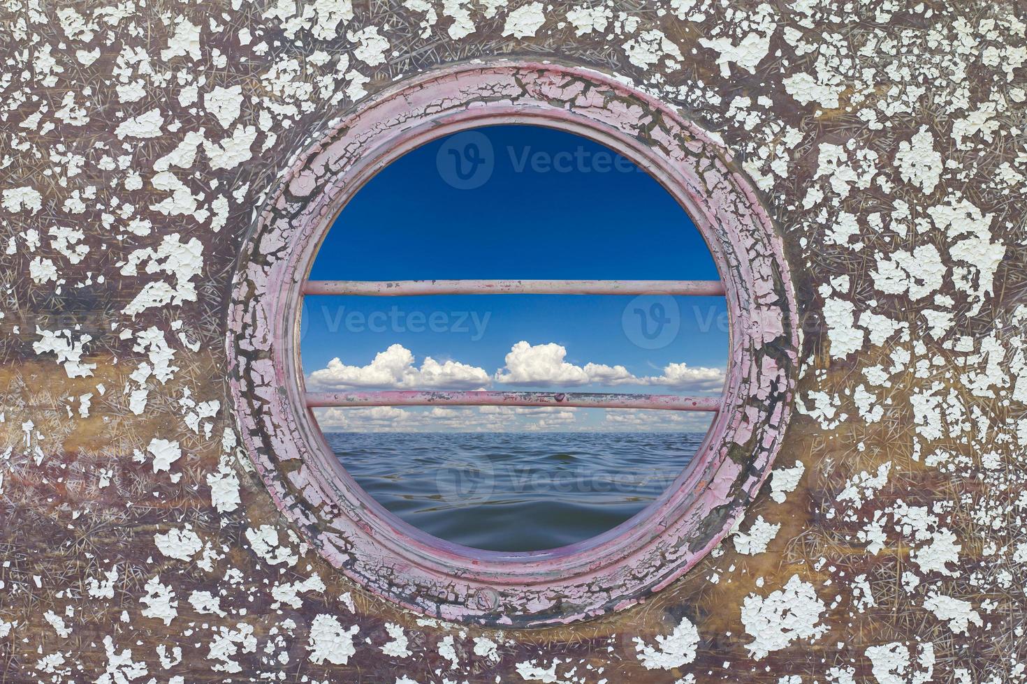 Peephole of boat with blue sea. photo