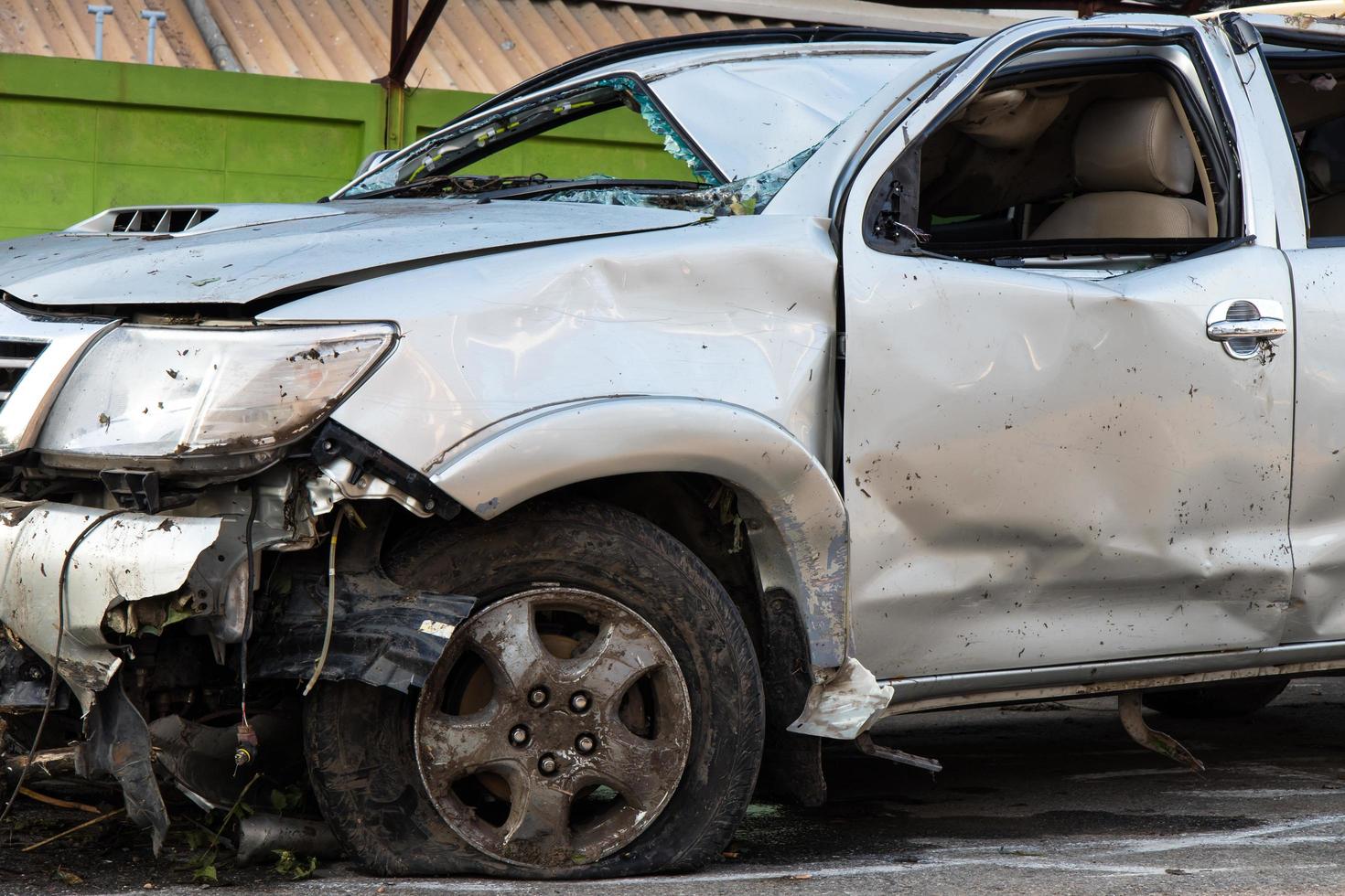 Front tire and wrecked cars. photo