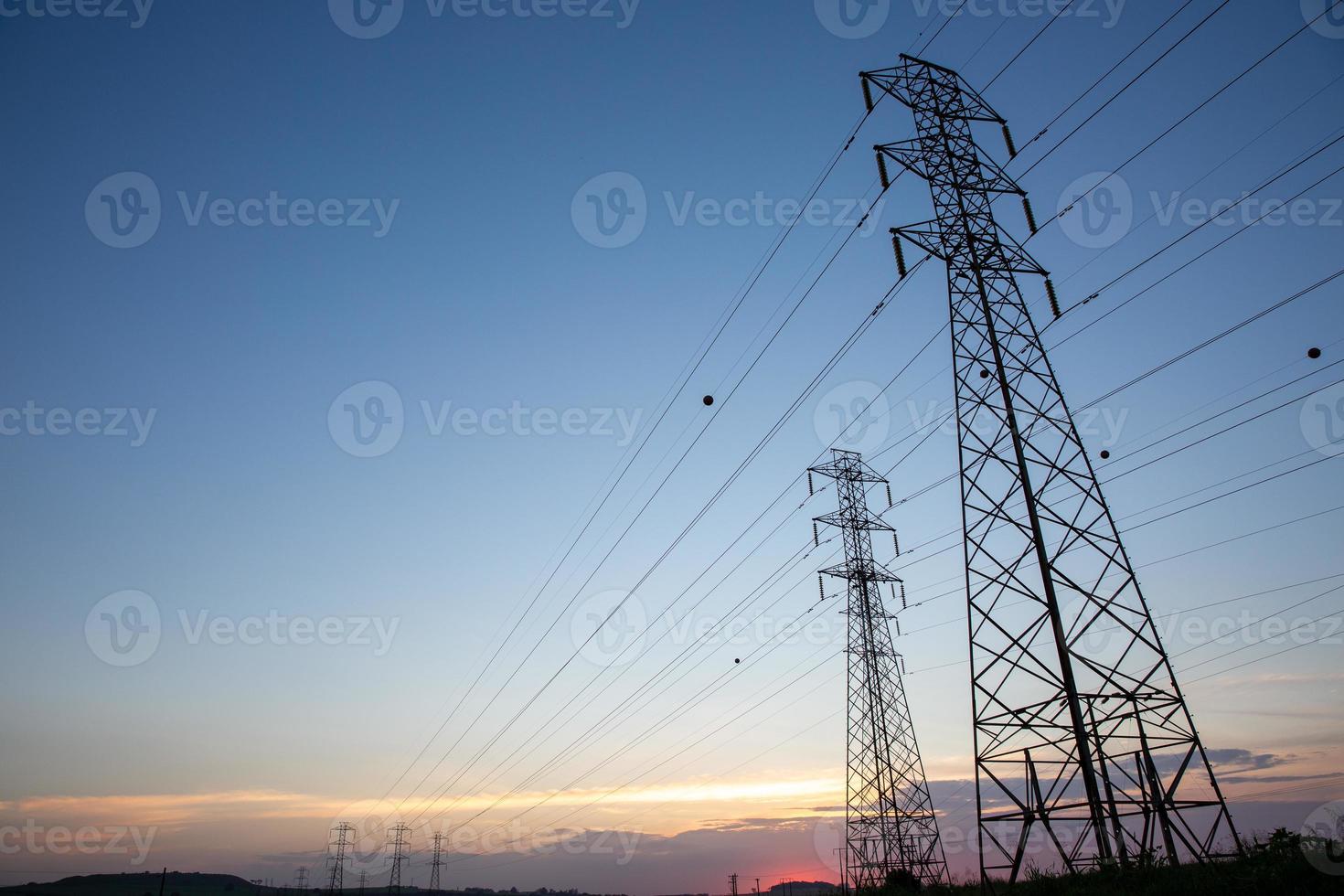 Look up High voltage of power transmission towers. Blue sky. photo