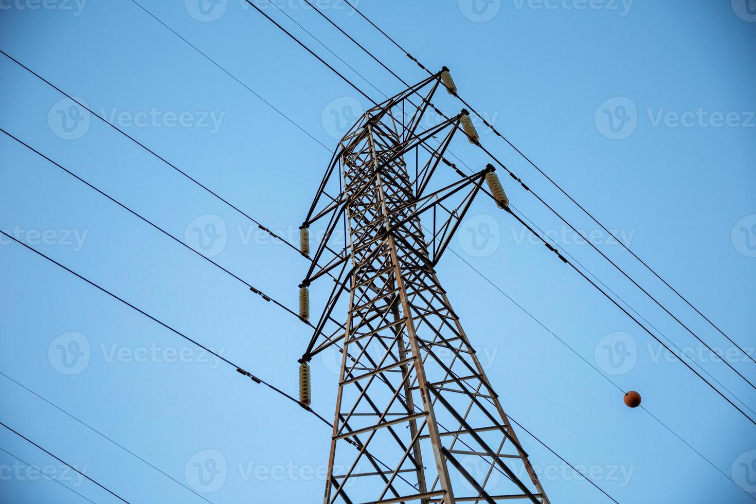 Look up High voltage of power transmission towers. Blue sky. photo