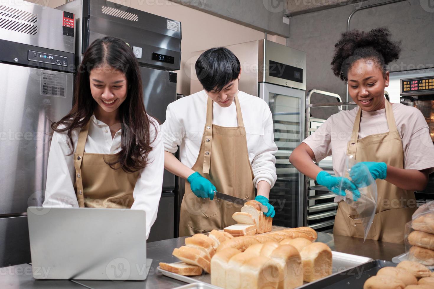 Three young friends and startup partners of bread dough and pastry foods busy with homemade baking jobs while cooking orders online, packing, and delivering on bakery shop, small business entrepreneur photo