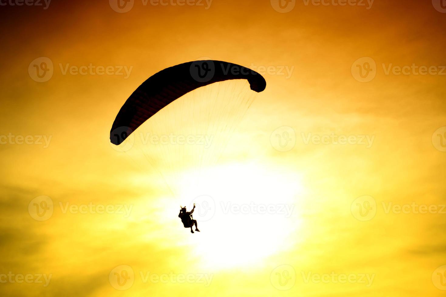 Silhouette of parachute on sunset photo