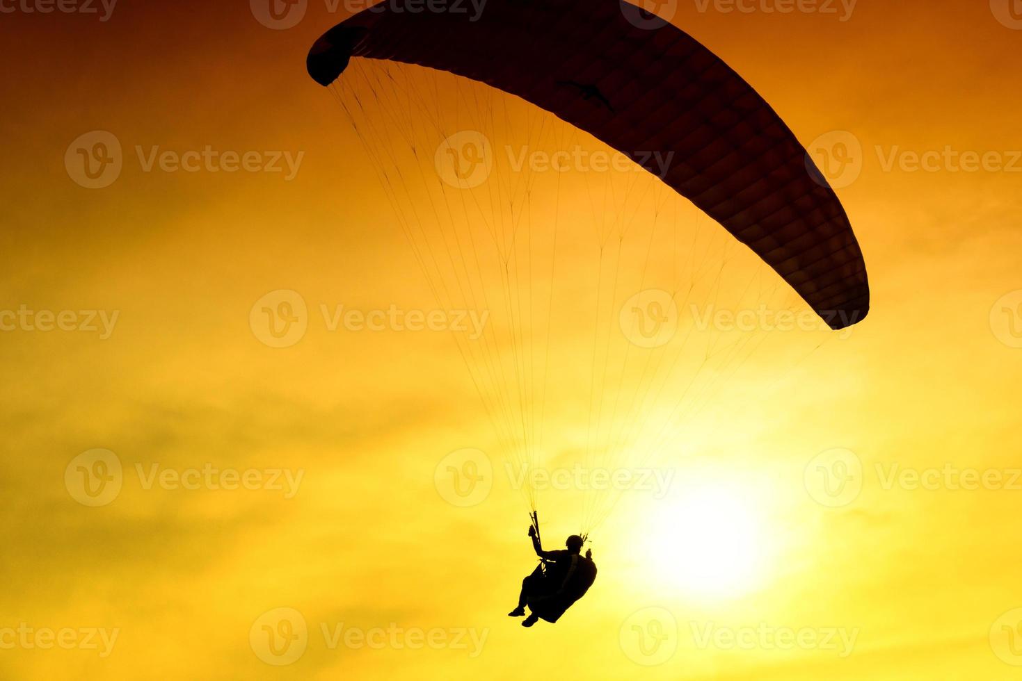 Silhouette of parachute on sunset photo