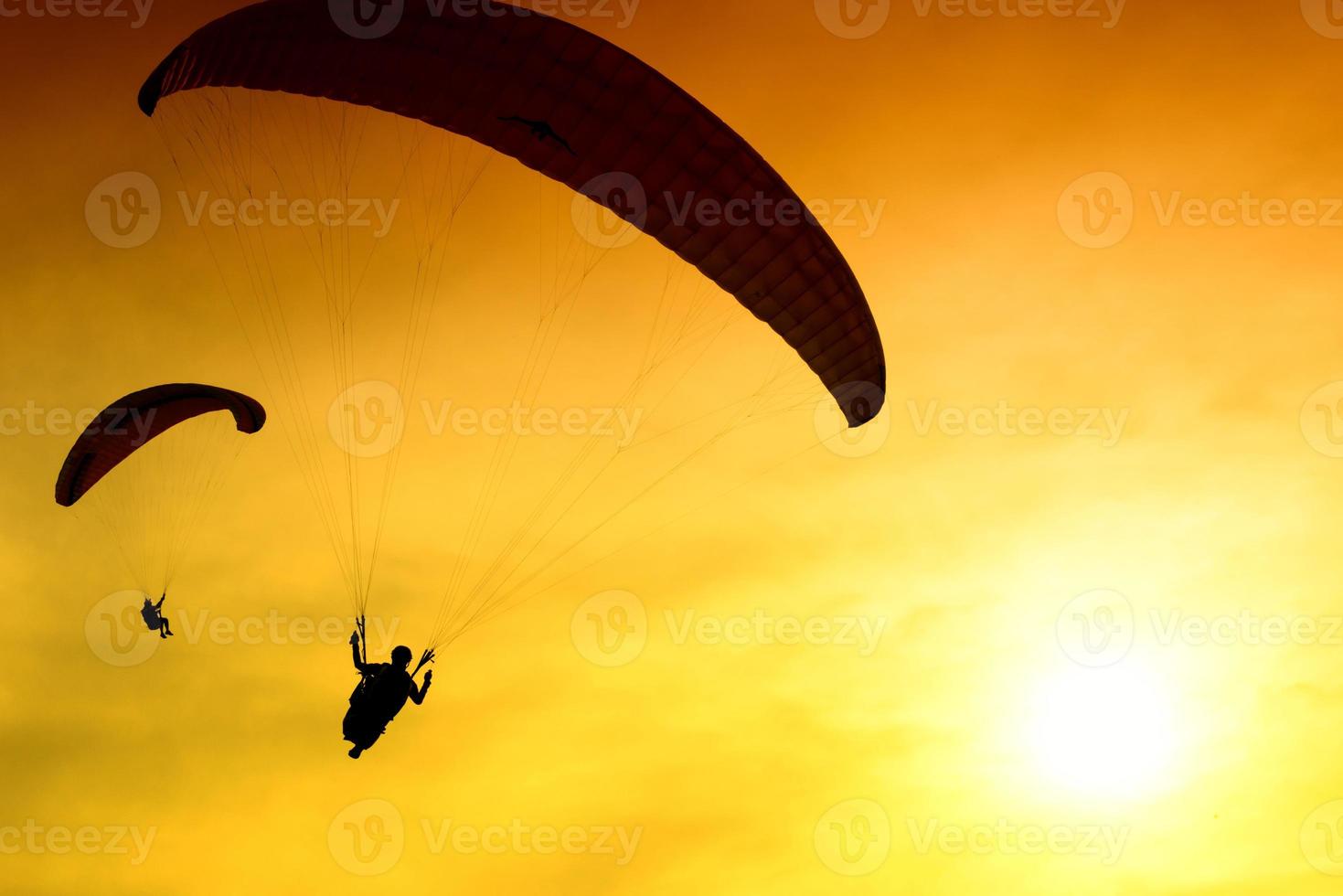 Silhouette of parachute on sunset photo