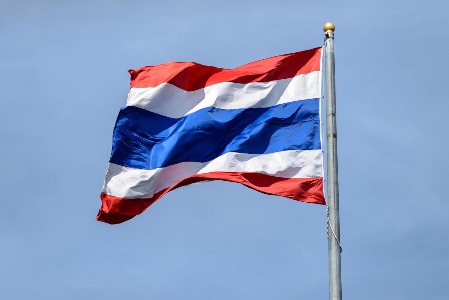 Waving Thai flag with blue sky background photo