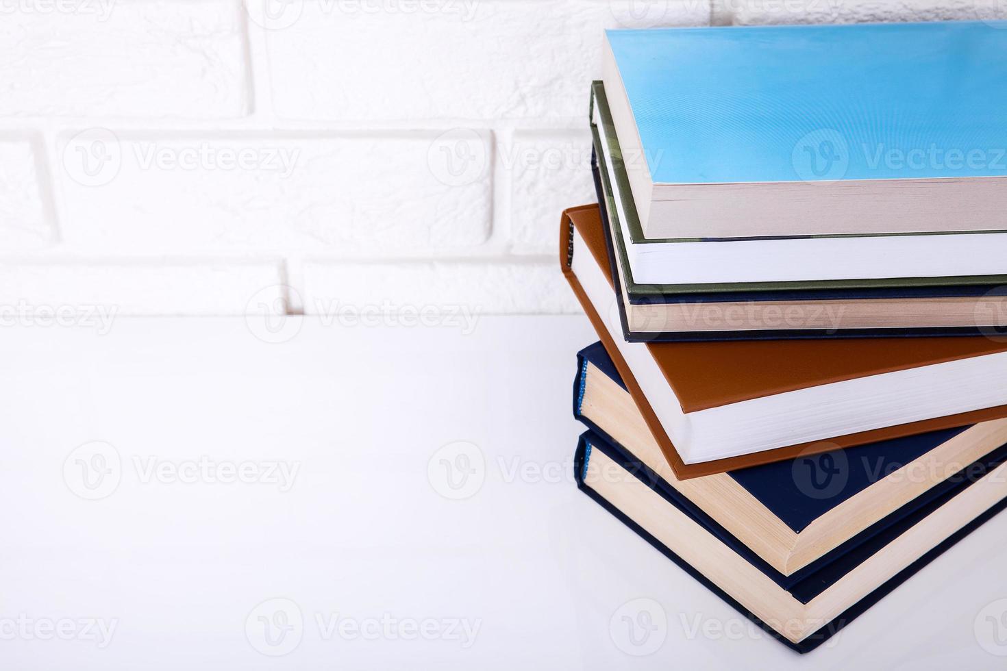 Books on the table near brick wall. Copy space and selective focus. Macro photo