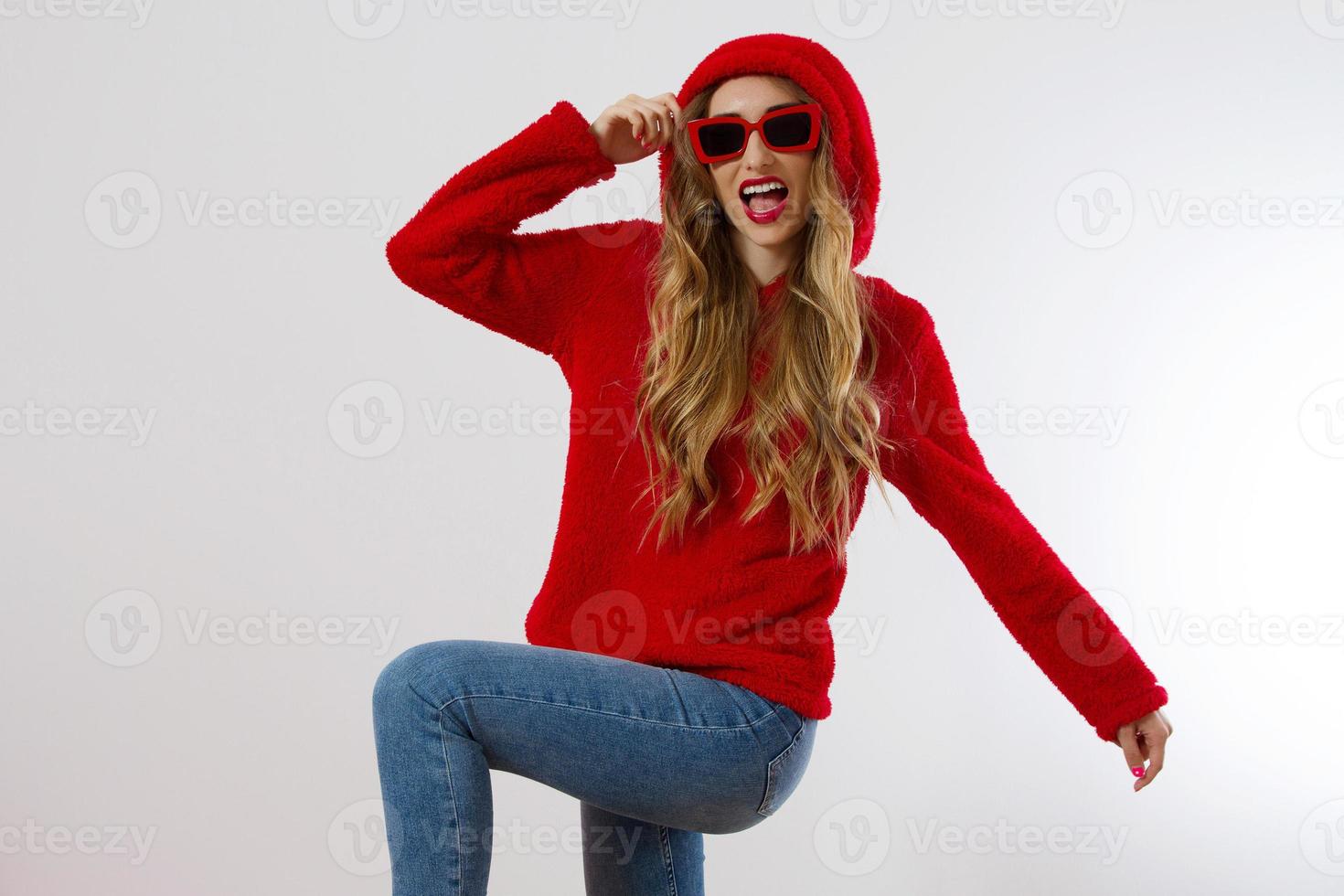 Closeup excited screaming young woman. shock, Shocked girl in red hoodie. Wow, surprised female. Fashion sweatshirt isolated on white background, face in red sunglasses. Beautiful, selective focus photo