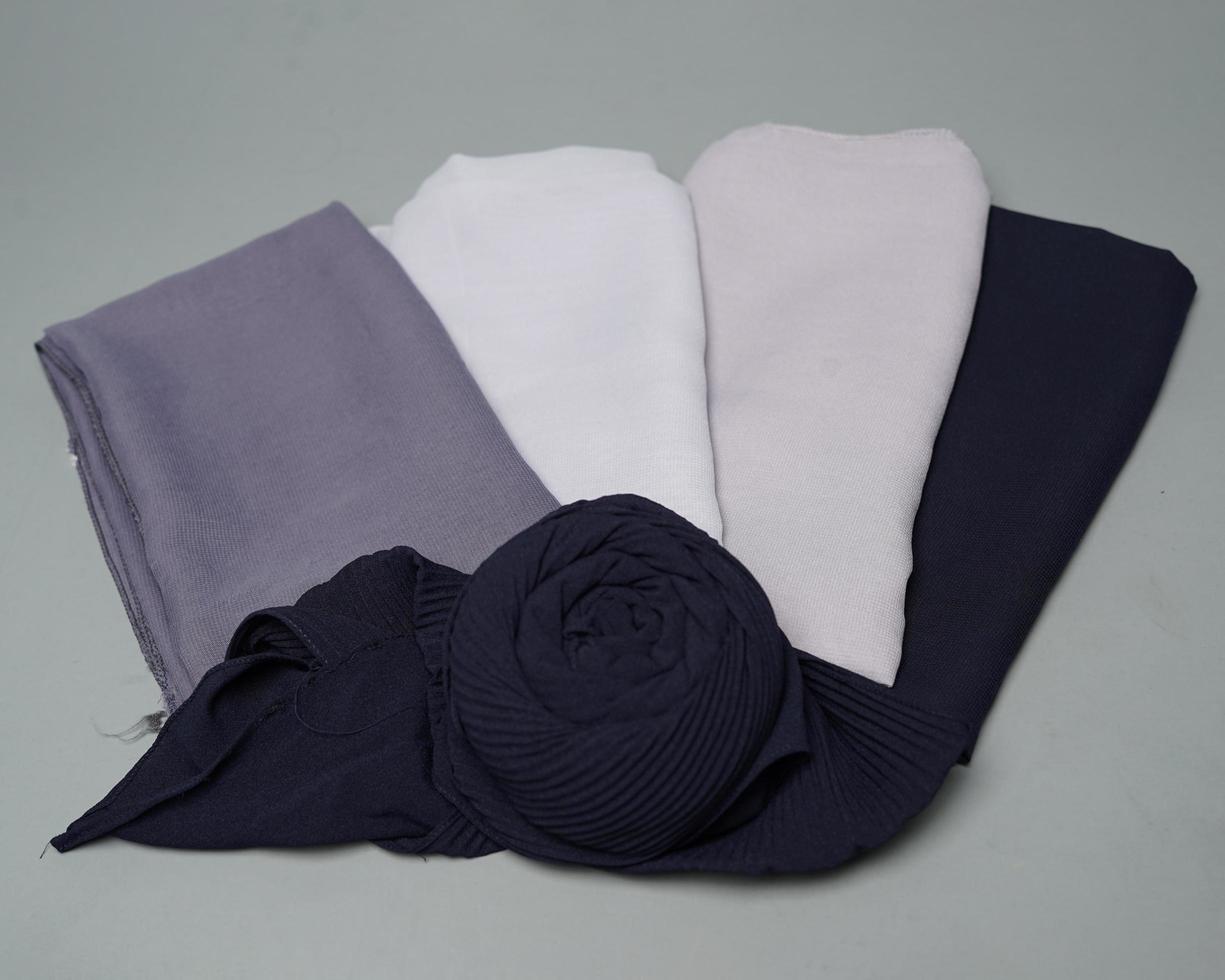 Stacks of nude colored veils neatly arranged on a gray background. Thin fabric blend of gray color that is ready to be used for Muslim women. Can also be used for sales displays. focus blur. hijab. photo