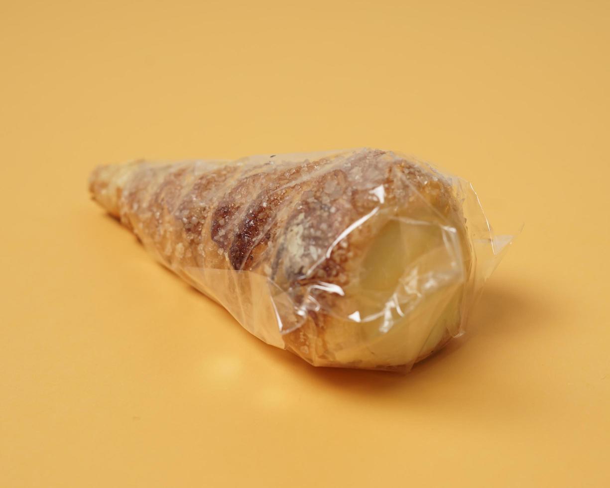 Indonesian cake shaped like ice cream with a cone sprinkled with sugar. This cake is usually called cumcum, or sometimes also called trumpet cake. The cake inside contains vanilla cream. focus blur. photo