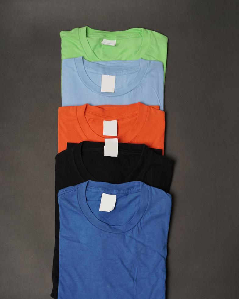 Stacks of plain cotton t-shirts neatly arranged. Plain colorful t-shirts, ready to be made into design mockups. T-shirts are clean without any branding. Men's blank T-shirt template. focus blur. eid photo