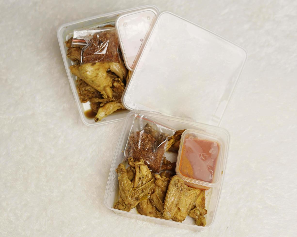 Chicken wrapped with Indonesian spices. Chicken pieces are ready to be fried. Ready-to-eat food in box packaging complete with chili sauce etc. Food packaging mockup box for template. Focus blur. photo