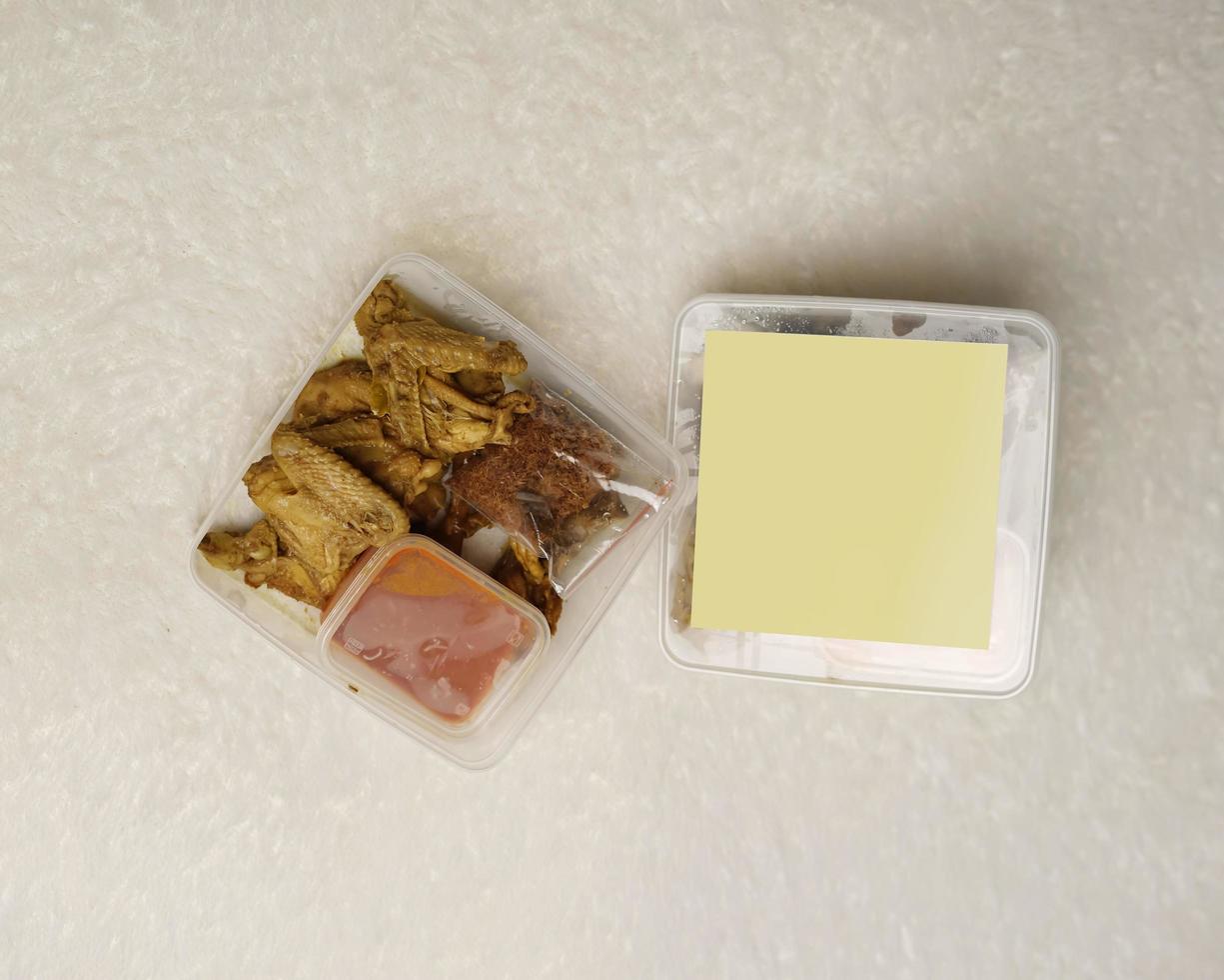 Chicken wrapped with Indonesian spices. Chicken pieces are ready to be fried. Ready-to-eat food in box packaging complete with chili sauce etc. Food packaging mockup box for template. Focus blur. photo