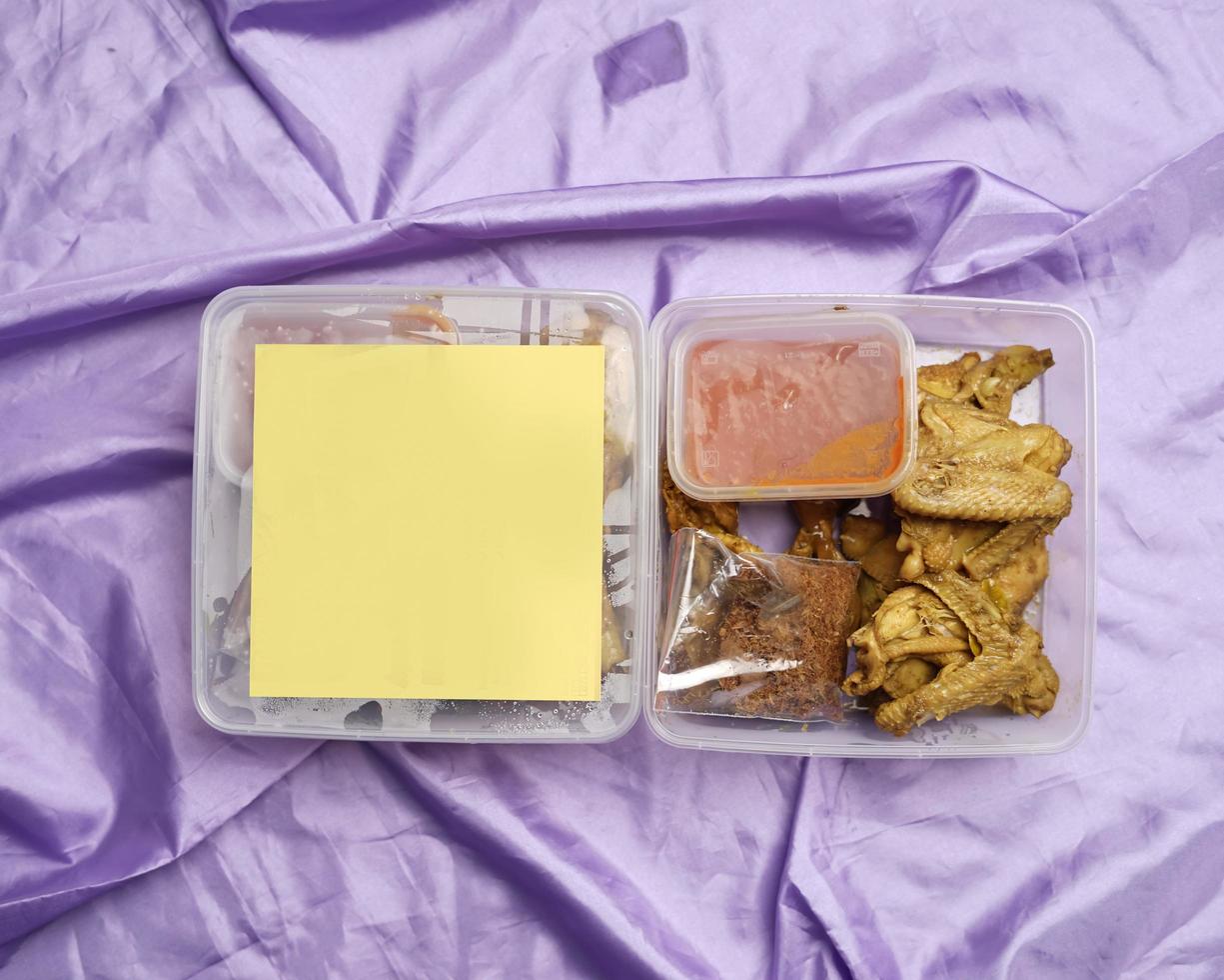 Chicken wrapped with Indonesian spices. Chicken pieces are ready to be fried. Ready-to-eat food in box packaging complete with chili sauce etc. Food packaging mockup box for template. Focus blur. photo