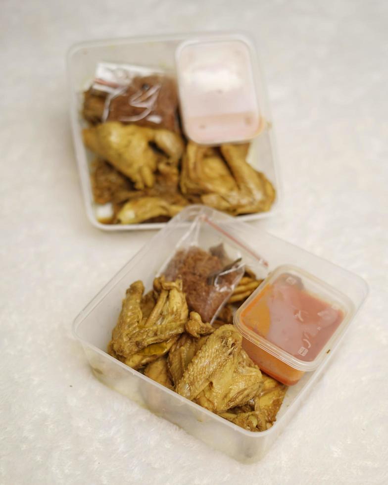 Chicken wrapped with Indonesian spices. Chicken pieces are ready to be fried. Ready-to-eat food in box packaging complete with chili sauce etc. Food packaging mockup box for template. Focus blur. photo