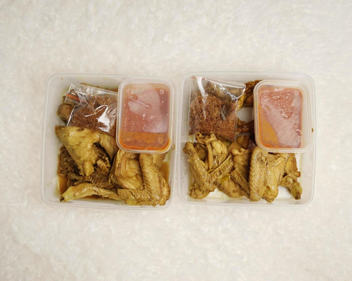 Chicken wrapped with Indonesian spices. Chicken pieces are ready to be fried. Ready-to-eat food in box packaging complete with chili sauce etc. Food packaging mockup box for template. Focus blur. photo