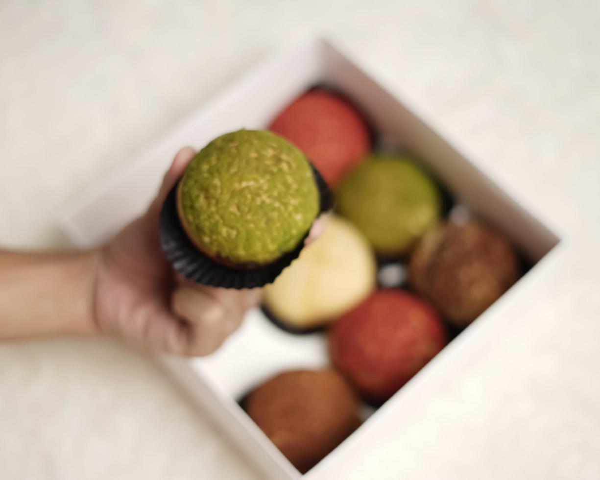 El craquelin choux es un canutillo japonés con una capa crujiente que tiene un sabor dulce y cremoso. creampuffs que contienen varios sabores de fla, vainilla, chocolate, matcha. eid cestas o paquetes. desenfoque de enfoque foto