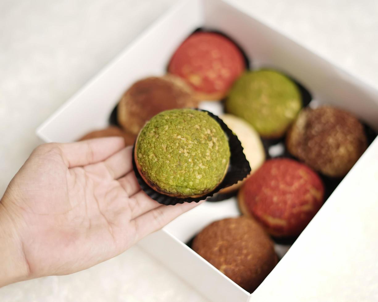 El craquelin choux es un canutillo japonés con una capa crujiente que tiene un sabor dulce y cremoso. creampuffs que contienen varios sabores de fla, vainilla, chocolate, matcha. eid cestas o paquetes. desenfoque de enfoque foto