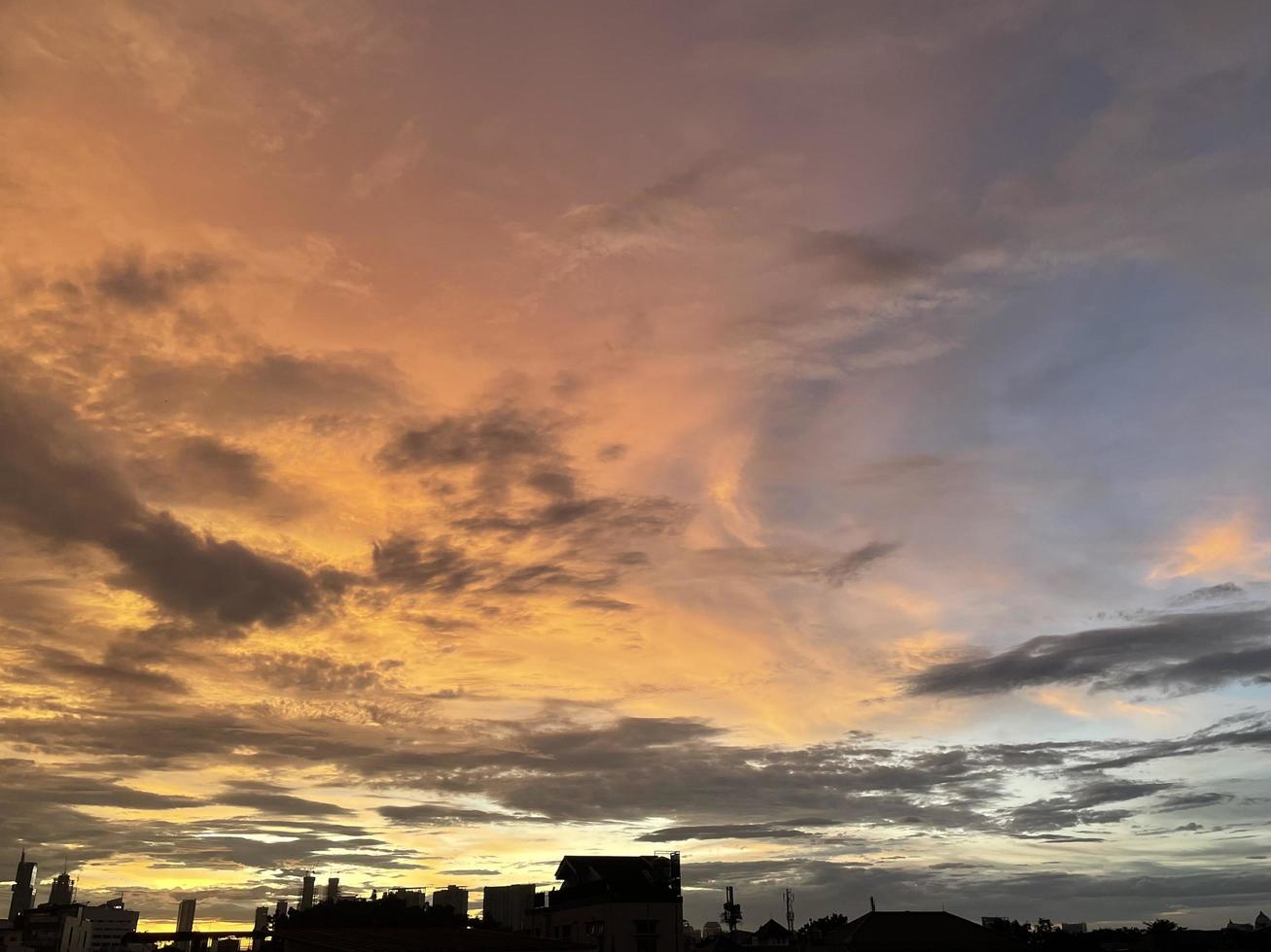 cielo crepuscular muy hermoso, una mezcla de colores naranja y azul. hermosa vista del cielo de la tarde. nubes, cielo y arcoíris que adornan el ambiente de la tarde. vista nocturna en Yakarta. difuminar foto