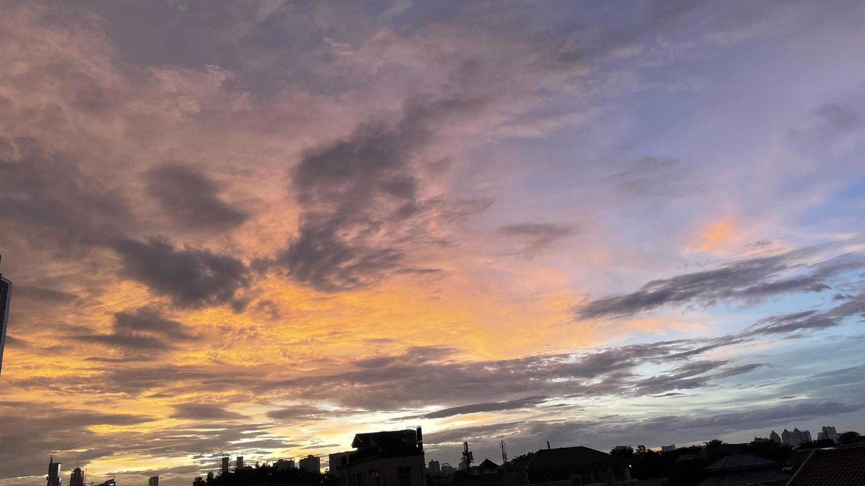 very beautiful twilight sky, a blend of orange and blue colors. beautiful view of the evening sky. clouds, sky and rainbow that adorn the atmosphere in the afternoon. Evening view in Jakarta. blur photo