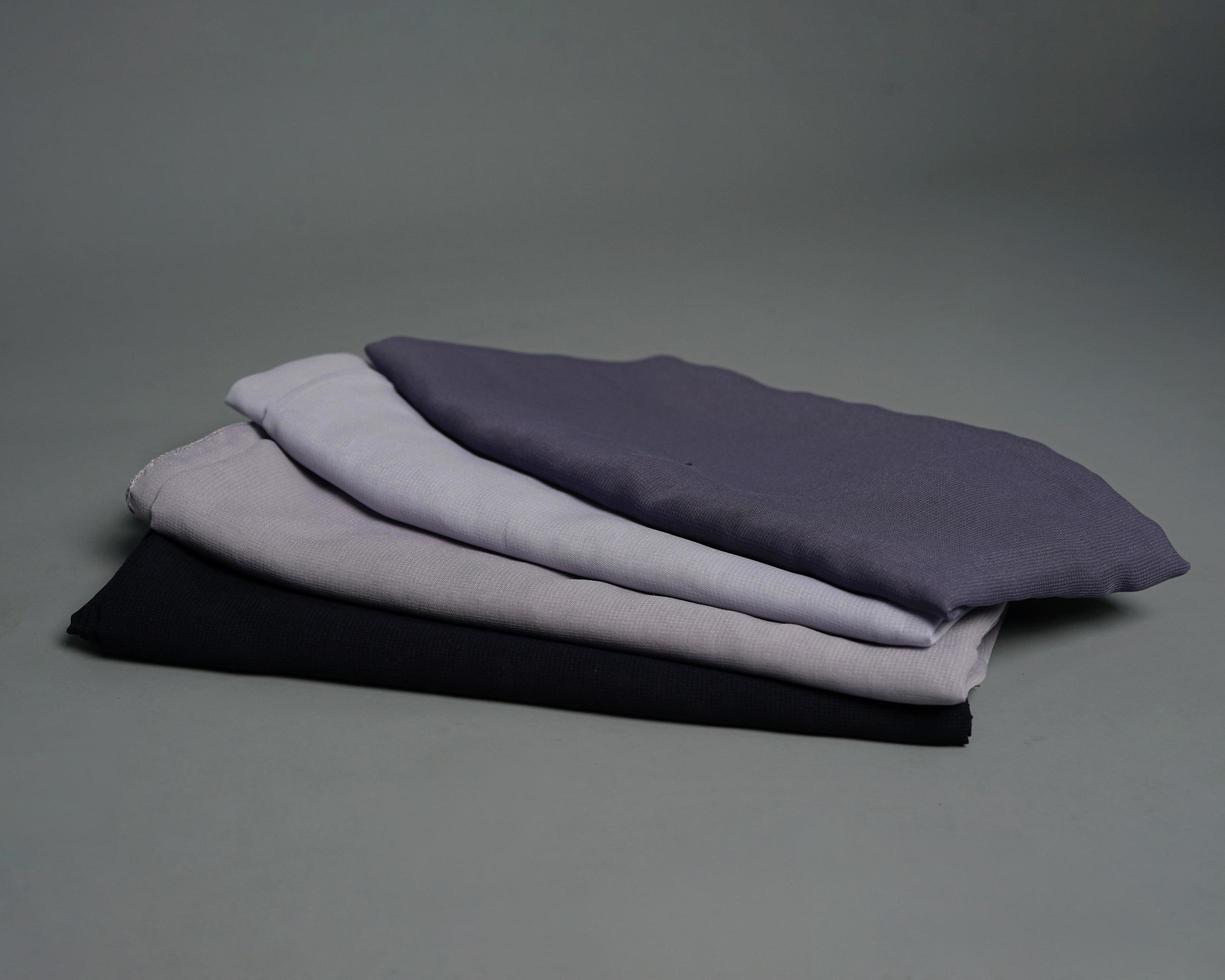 Stacks of nude colored veils neatly arranged on a gray background. Thin fabric blend of gray color that is ready to be used for Muslim women. Can also be used for sales displays. focus blur. hijab. photo