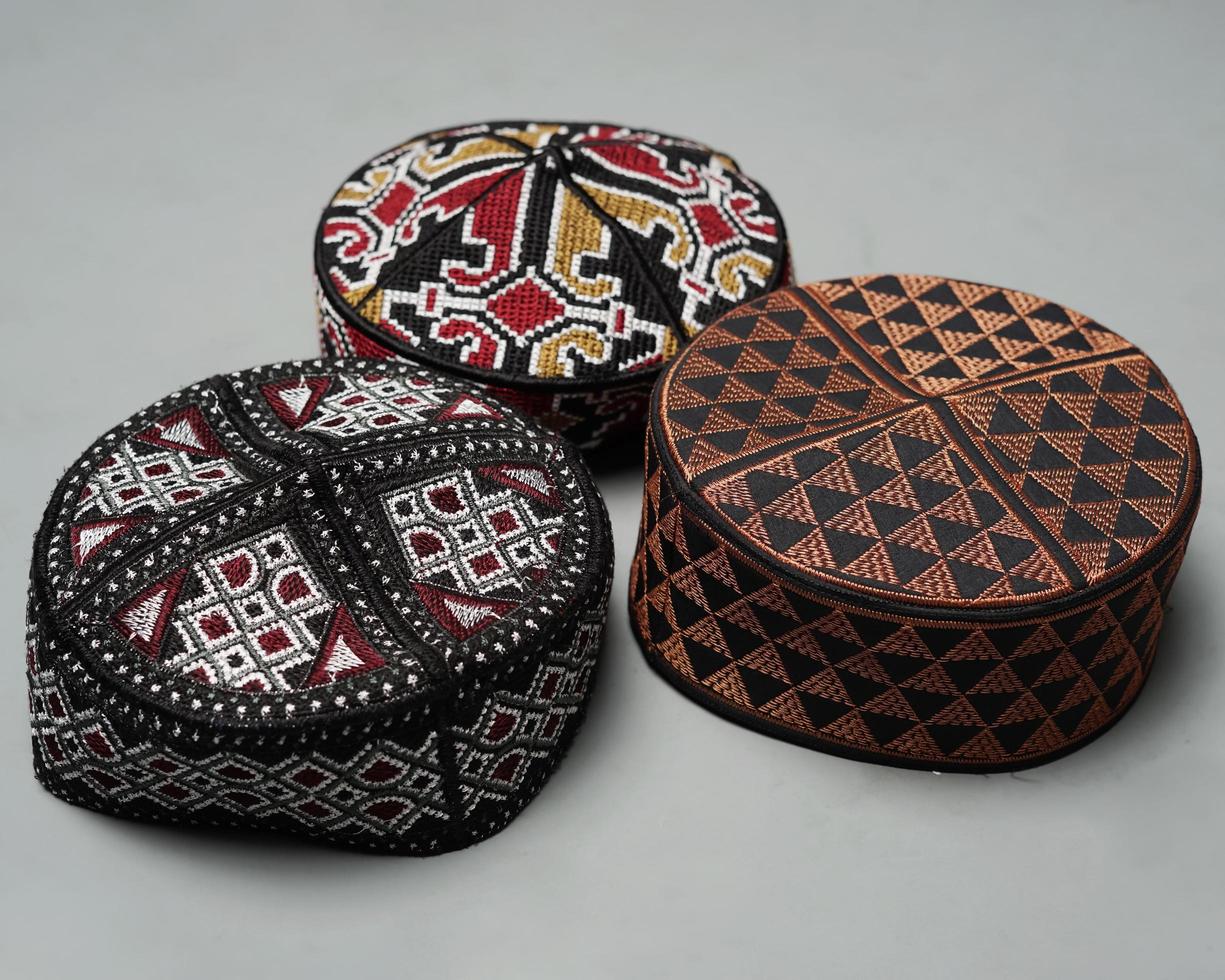 Collection of kopiah hat or peci with a variety of color and shape motifs. Peci that is usually used for Muslim men while praying to the mosque. Islamic cap isolated on white background. Ied mubarok. photo