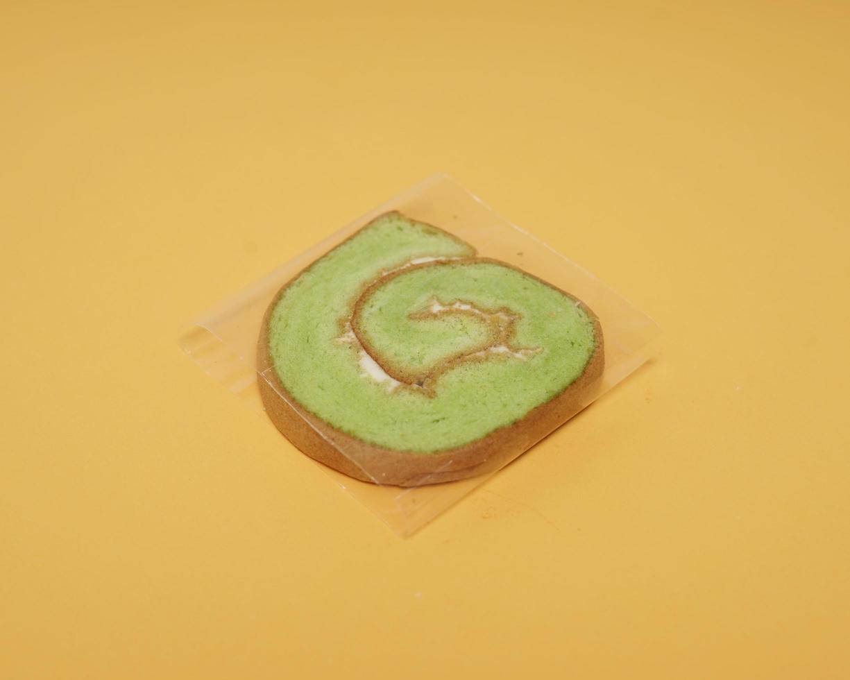 Slices of bread covered with cream butter are then rolled and sliced. Bread in the shape of a roll. The green color usually indicates the pandan flavor in the bread. Indonesian cake taste. focus blur. photo