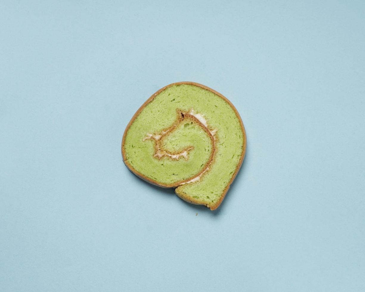 Slices of bread covered with cream butter are then rolled and sliced. Bread in the shape of a roll. The green color usually indicates the pandan flavor in the bread. Indonesian cake taste. focus blur. photo