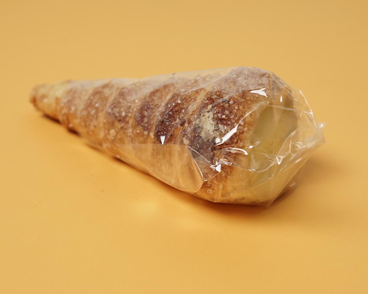 Indonesian cake shaped like ice cream with a cone sprinkled with sugar. This cake is usually called cumcum, or sometimes also called trumpet cake. The cake inside contains vanilla cream. focus blur. photo