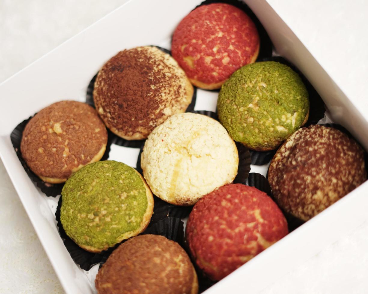 El craquelin choux es un canutillo japonés con una capa crujiente que tiene un sabor dulce y cremoso. creampuffs que contienen varios sabores de fla, vainilla, chocolate, matcha. eid cestas o paquetes. desenfoque de enfoque foto