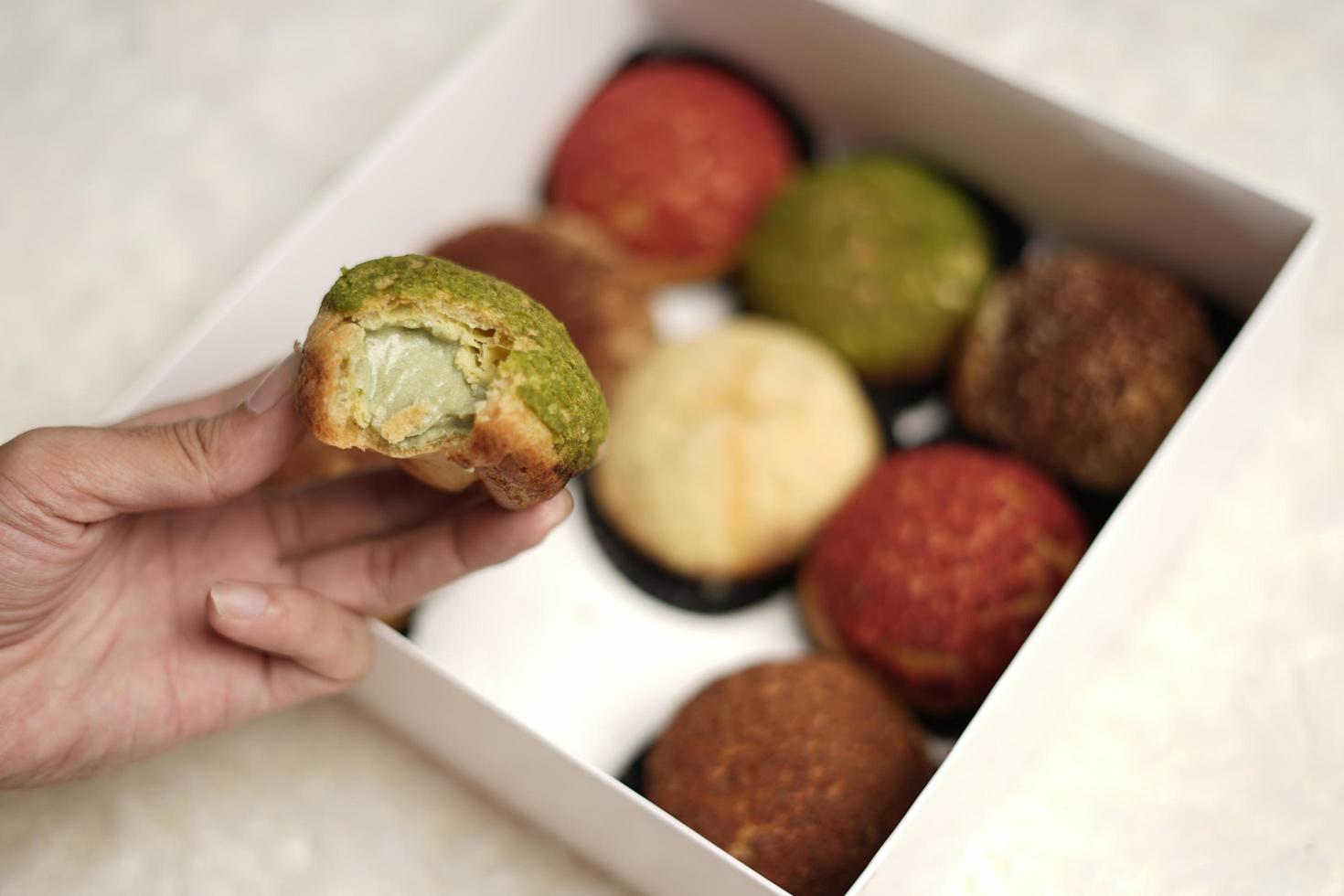 El craquelin choux es un canutillo japonés con una capa crujiente que tiene un sabor dulce y cremoso. creampuffs que contienen varios sabores de fla, vainilla, chocolate, matcha. eid cestas o paquetes. desenfoque de enfoque foto