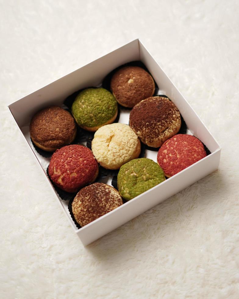 Craquelin choux is a Japanese eclairs with a crispy coating that tastes sweet and creamy. Creampuffs containing various flavors of fla, vanilla, chocolate, matcha. Eid hampers or parcels. focus blur. photo